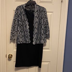 Black sleeveless round neck cocktail dress with lace black and silver jacket.